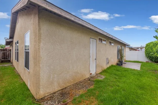 a backyard of a house with plants and wooden fence