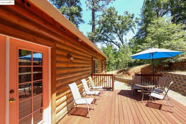 a view of backyard with deck and outdoor seating