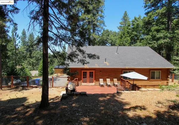 a view of backyard with deck and outdoor seating