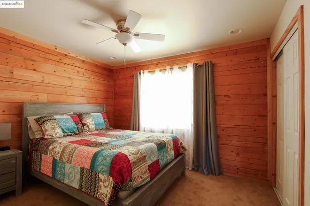 a bedroom with a bed and a ceiling fan