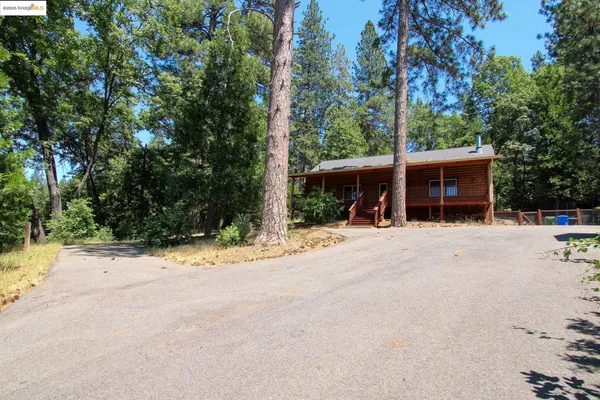 a view of a house with a yard and road