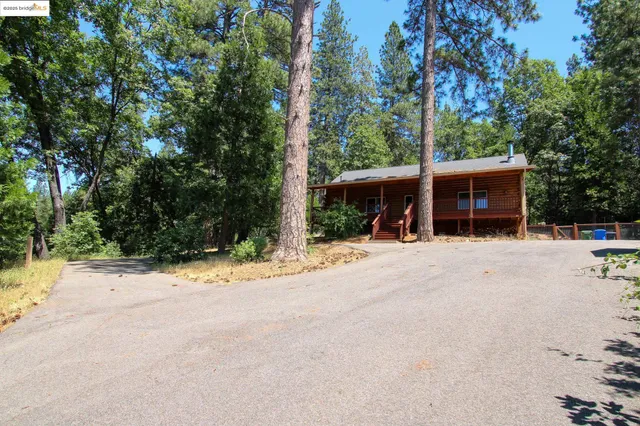 a view of a house with a yard and road