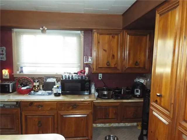 a kitchen with stainless steel appliances kitchen island granite countertop a refrigerator a stove and a sink with wooden floor