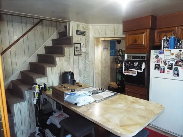 a kitchen with stainless steel appliances kitchen island granite countertop a sink stove and refrigerator