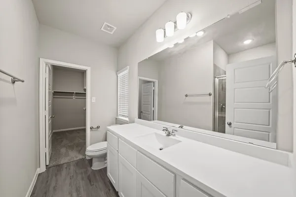 a bathroom with a double vanity sink mirror and toilet
