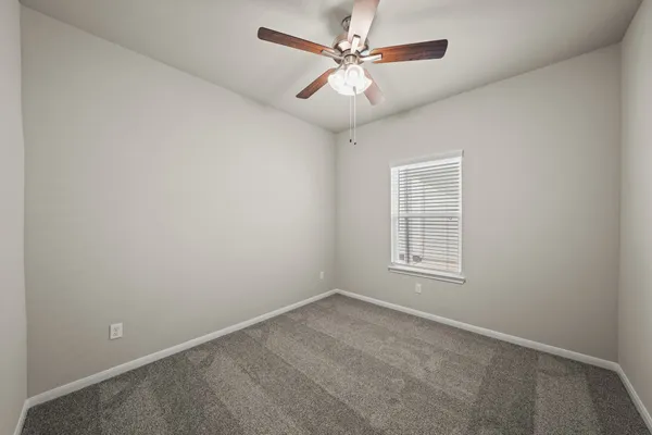 an empty room with a window and a fan