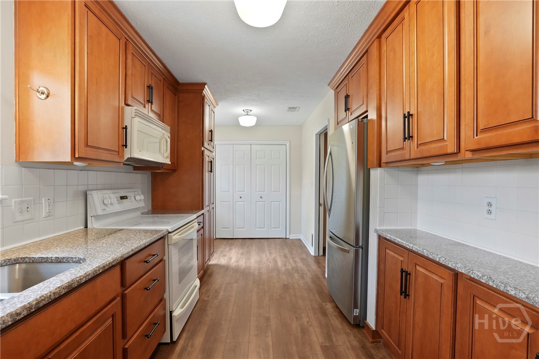 13609 Rockingham Road Savannah, GA 31419 - Photo 29 of 39 Kitchen features raised panel wood cabinets with crown molding & granite counters
