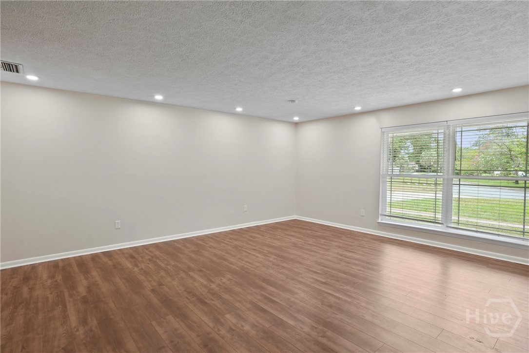 13609 Rockingham Road Savannah, GA 31419 - Photo 9 of 39 Living room with vinyl plank flooring & floor to ceiling vinyl windows