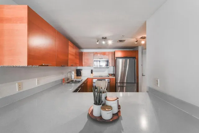 a kitchen with stainless steel appliances granite countertop a refrigerator and a sink