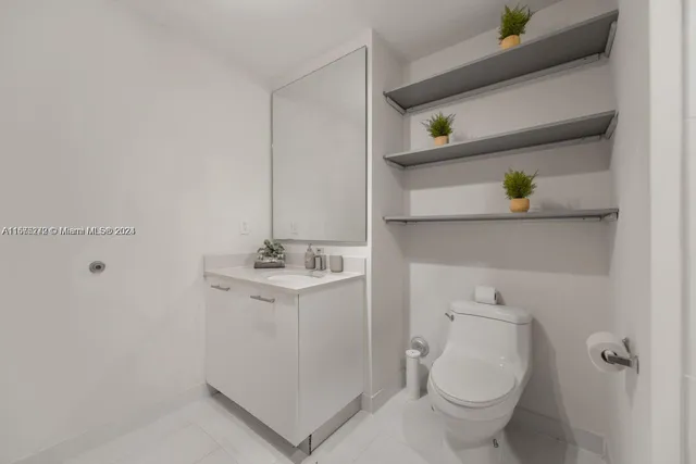 a white toilet sitting next to a shower
