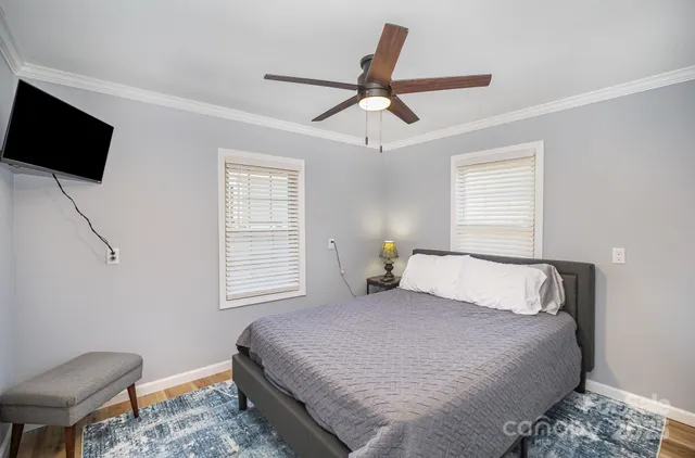 a bedroom with a bed and a flat tv screen on the dresser