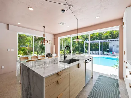 a kitchen with kitchen island a large window in it