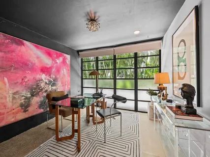 a living room with furniture a flat screen tv and a floor to ceiling window