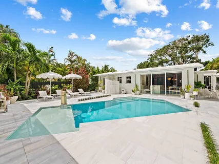 a view of a house with swimming pool and sitting area