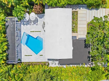 an aerial view of a houses with a lush green hillside