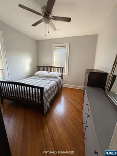 a bedroom with bed and wooden floor