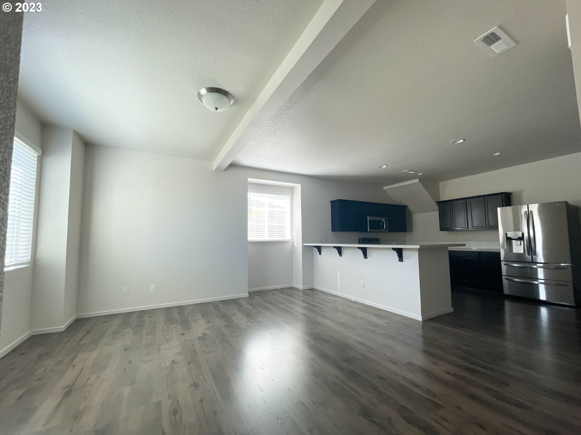 2211 Southeast 19th Street Gresham, OR 97080 - Photo 3 of 16 an empty room with wooden floor and a kitchen