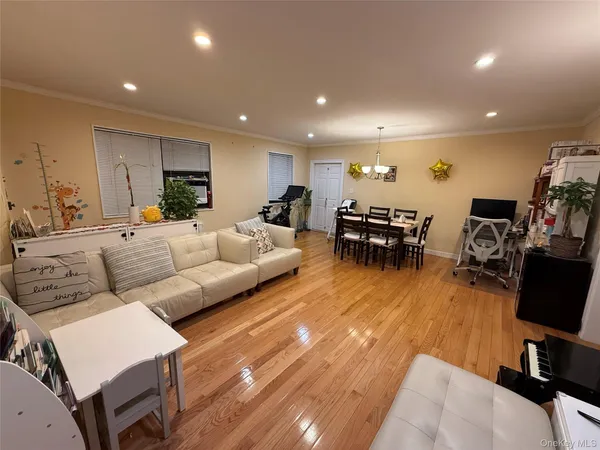 a living room with furniture a wooden floor and a flat screen tv