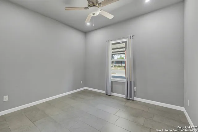 an empty room with closet and fan