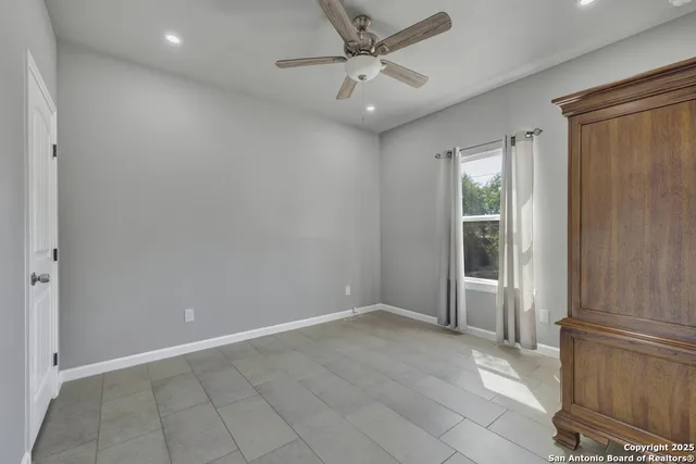 an empty room with windows and fan