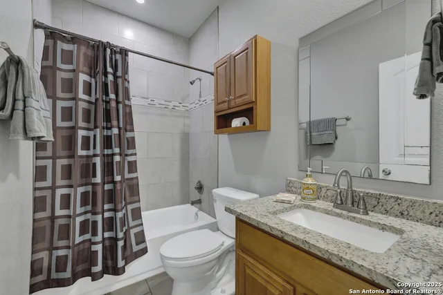 a bathroom with a granite countertop sink toilet and shower