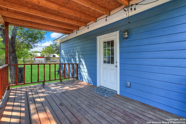 a view of backyard with green space and wooden fence