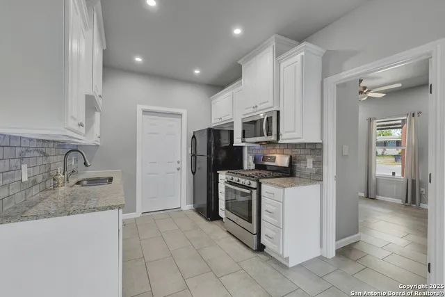 a kitchen with stainless steel appliances granite countertop a refrigerator and a sink