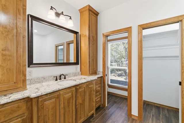 a bathroom with a granite countertop sink and a mirror