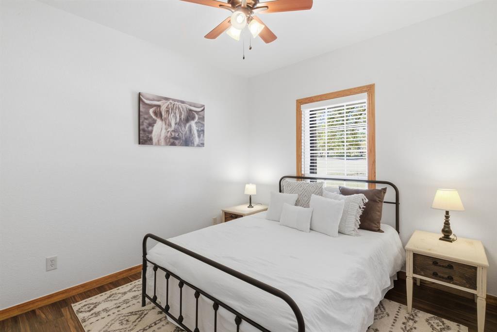 160 Falcon Drive Weatherford, TX 76088 - Photo 20 of 40 a bedroom with a bed and a chandelier