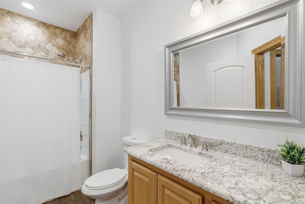 160 Falcon Drive Weatherford, TX 76088 - Photo 21 of 40 a bathroom with a granite countertop sink a toilet and a mirror