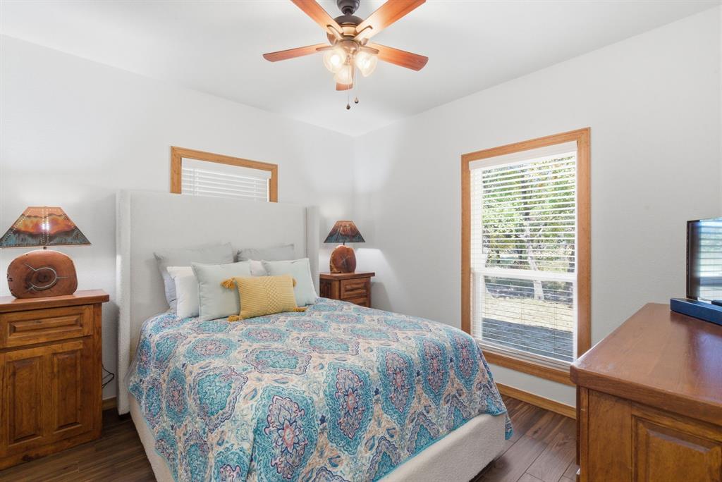 160 Falcon Drive Weatherford, TX 76088 - Photo 22 of 40 a bedroom with a bed and a chandelier