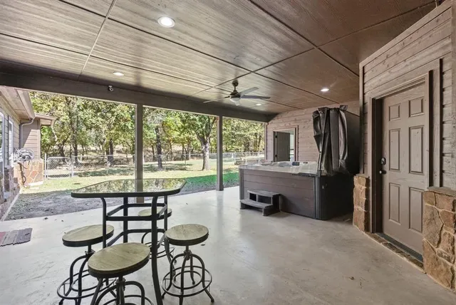 a view of a patio with table and chairs and wooden fence