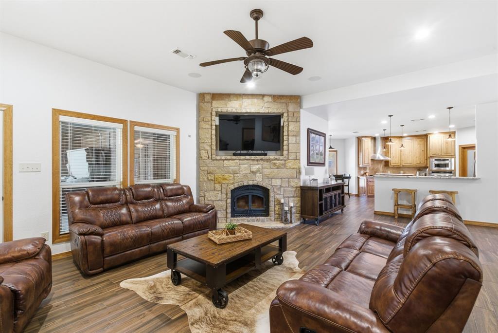 160 Falcon Drive Weatherford, TX 76088 - Photo 5 of 40 a living room with furniture a fireplace and a flat screen tv
