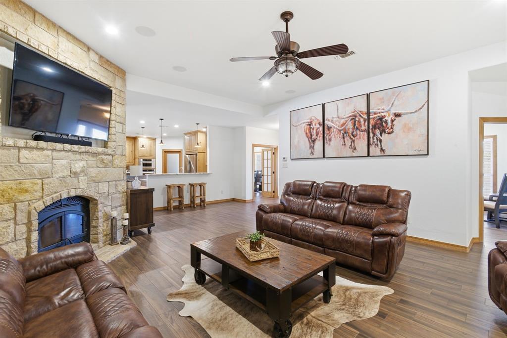 160 Falcon Drive Weatherford, TX 76088 - Photo 6 of 40 a living room with furniture a flat screen tv and a fireplace