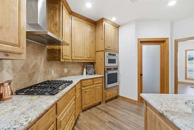 a kitchen with stainless steel appliances granite countertop a stove a sink and a refrigerator