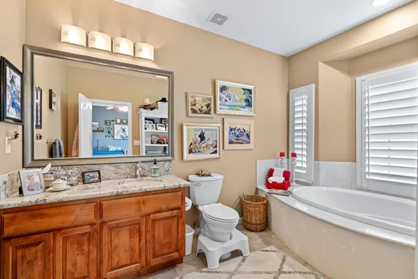a bathroom with a granite countertop sink a mirror and shower