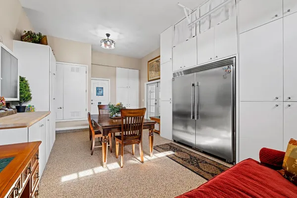 a bedroom with a bed a dresser and a chandelier