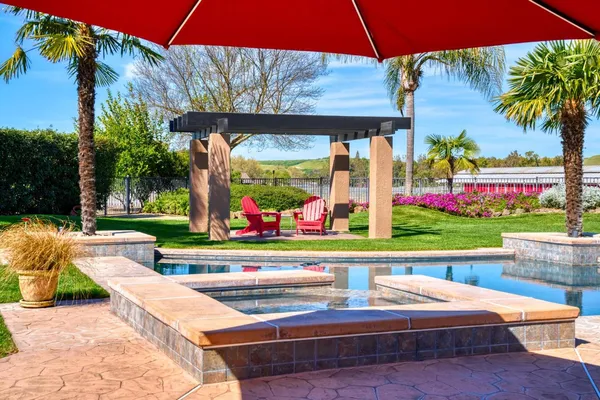 a front view of a house with a yard and potted plants