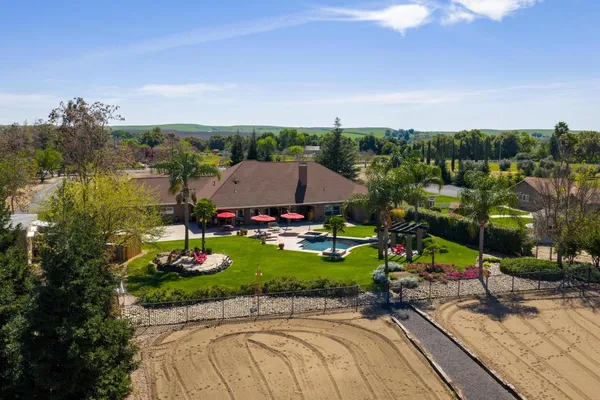 a front view of a house with a yard and trees