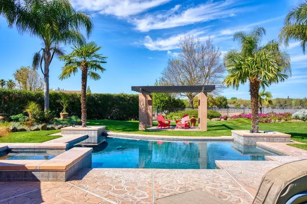 a kitchen with stainless steel appliances granite countertop a stove a sink dishwasher a dining table and chairs with wooden floor