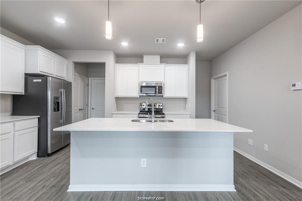 1326 Prairie Drive, Unit 621 Bryan, TX 77803 - Photo 8 of 20 a view of a kitchen with kitchen island a sink stainless steel appliances and cabinets