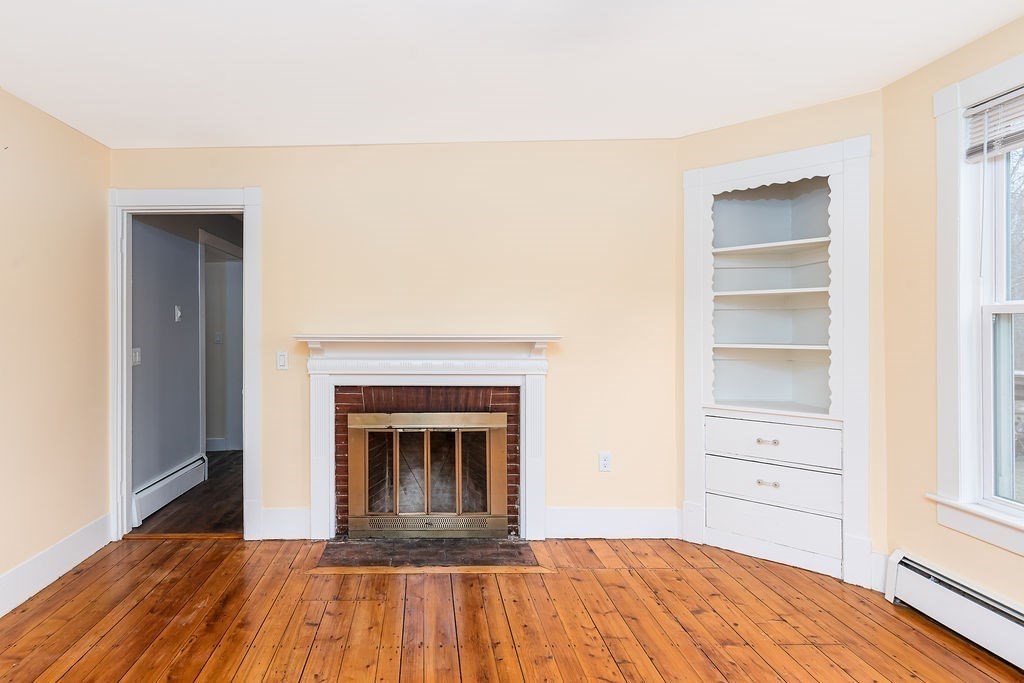 363 Concord Road Billerica, MA 01821 - Photo 8 of 42 a view of a livingroom with wooden floor and a fireplace