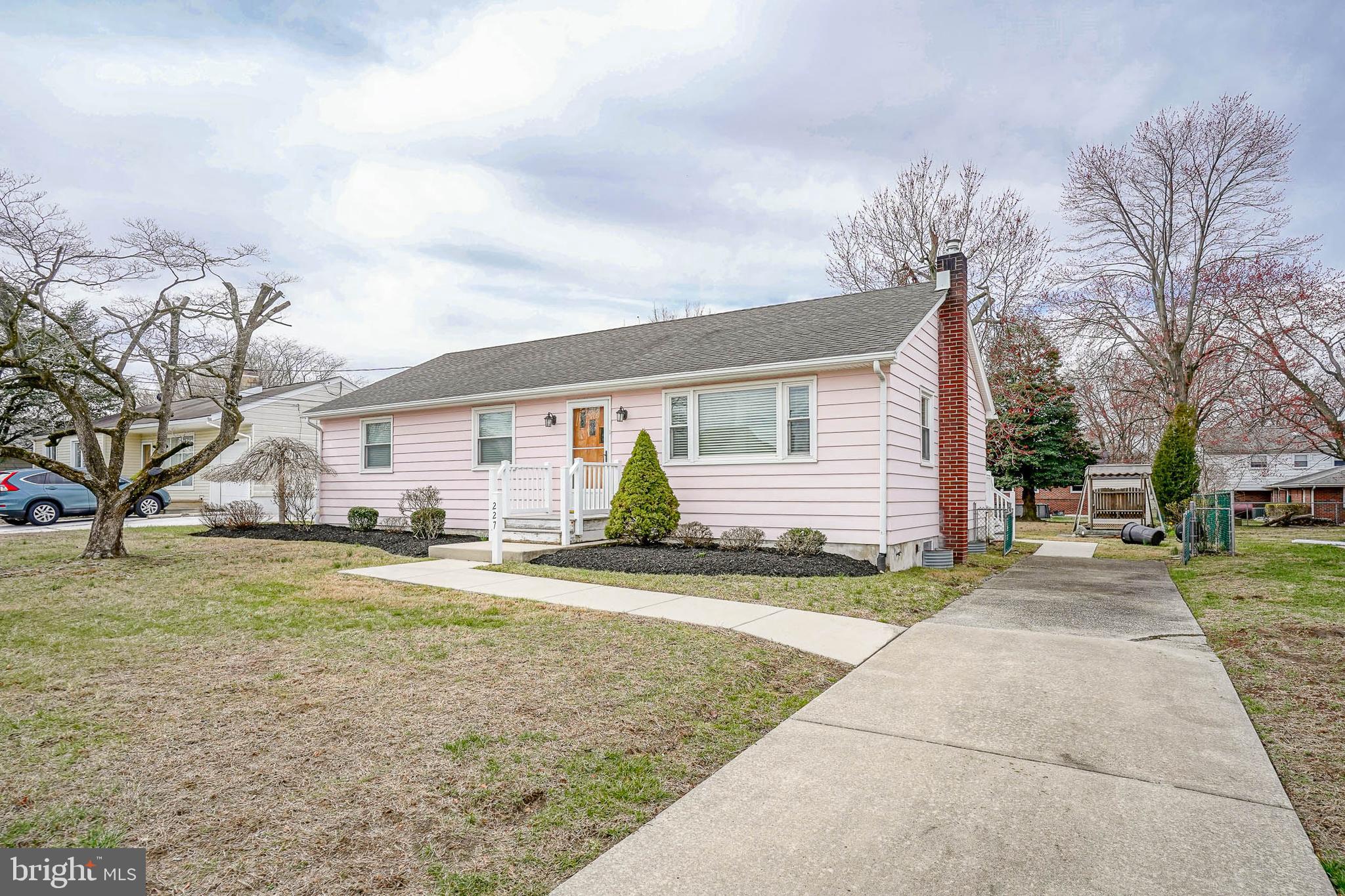 a front view of house with yard and trees around