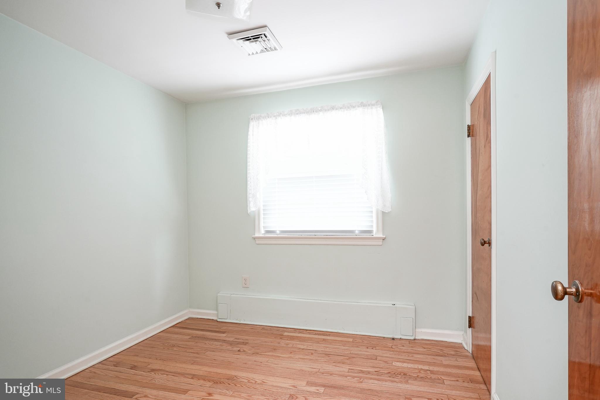 227 Harmony Road Gibbstown, NJ 08027 - Photo 16 of 29 an empty room with wooden floor and windows