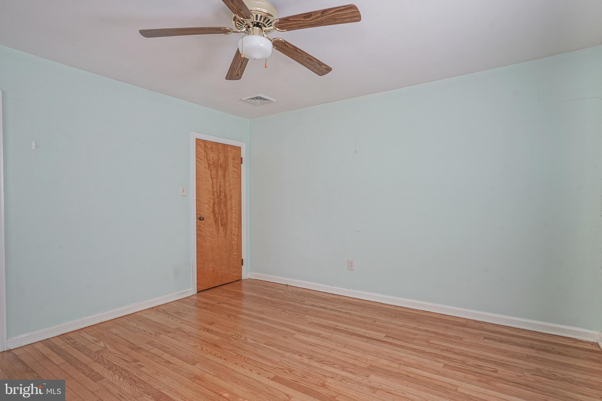 227 Harmony Road Gibbstown, NJ 08027 - Photo 22 of 29 a view of an empty room with wooden floor and a ceiling fan