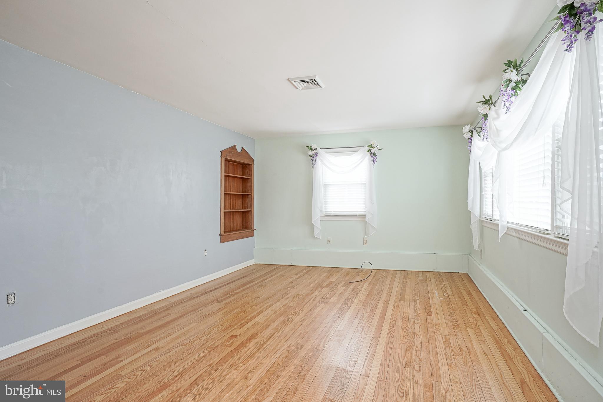 227 Harmony Road Gibbstown, NJ 08027 - Photo 3 of 29 wooden floor in an empty room with a window