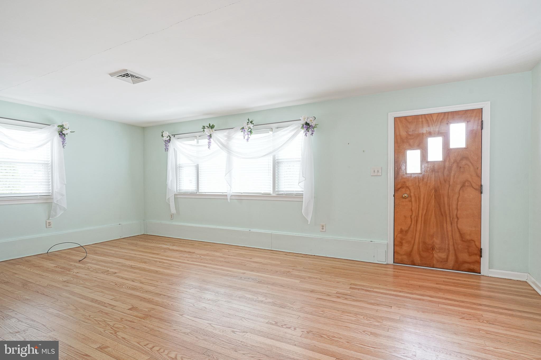 227 Harmony Road Gibbstown, NJ 08027 - Photo 4 of 29 a view of an empty room with wooden floor and a window