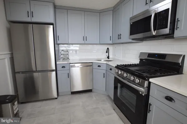 a kitchen with stainless steel appliances a stove microwave and refrigerator