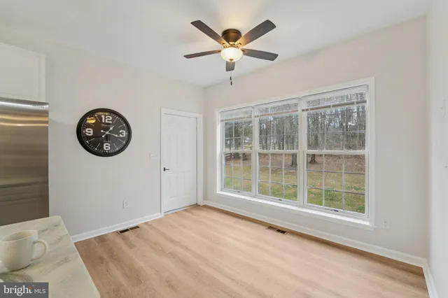 a view of a dining room with furniture a chandelier and wooden floor