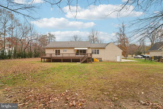 a view of a house with a wooden deck and a yard